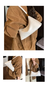 Détail du sac demi-lune en cuir verni blanc brillant avec anneaux dorés en métal