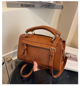 Détail d'un sac à main rectangulaire marron en simili cuir avec nœud décoratif