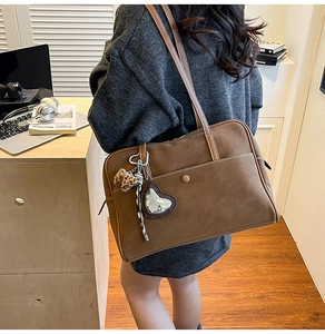 Brown tote bag detail with leopard print charm and heart pendant on faux suede