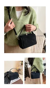 Détail d'un sac à bandoulière carré noir vintage avec fermoir rotatif en métal poli