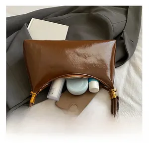 Vue intérieure du sac bandoulière en cuir marron brillant montrant sa grande capacité