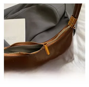 Vue détaillée du sac croissant marron foncé avec fermeture éclair dorée élégante