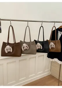 Detail view of four textured leather tote bags in various colors with cute rabbit charms
