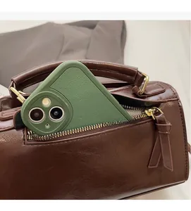 Détail de la poche zippée latérale d'un sac en cuir marron montrant l'espace pour téléphone