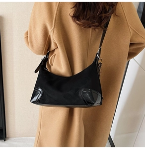 Dettaglio della borsa hobo nera opaca con angoli in vernice e tracolla marrone scuro