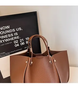Close-up of dark brown lychee pattern leather tote bag with smooth rounded handles