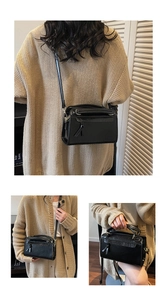 Détail du sac Boston en cuir noir mat avec gland à nœud et bandoulière réglable