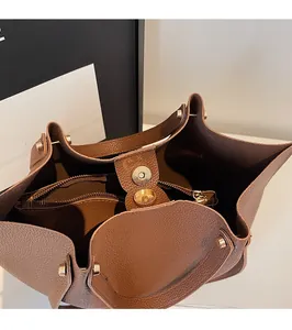 Close-up of magnetic buckle closure and textured lychee leather on dark brown tote