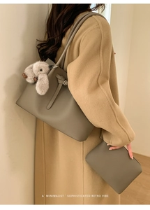Detail of grey retro tote bag with lychee texture and plush rabbit pendant charm