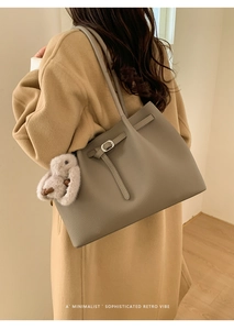 Detailed texture of gray lychee leather tote bag with elegant rabbit plush charm