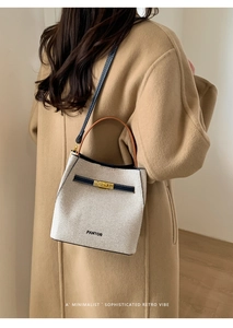 Detailed side view of vintage woven bucket bag with leather trim on model