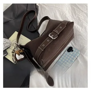 Detail of retro brown suede shoulder bag with silver buckle and leopard heart charm