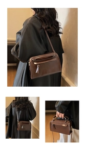 Détail du sac Boston en cuir marron foncé avec bandoulière réglable et structure vintage