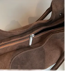 Primer plano de la cremallera metálica plateada en el bolso tote marrón vintage mate