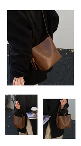 Detail of vintage brown leather bucket bag with adjustable strap and metallic buckle