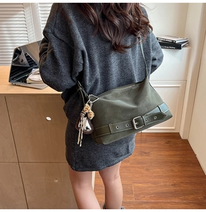 Olive green matte tote bag with metal buckle shown from a side-view angle on a model