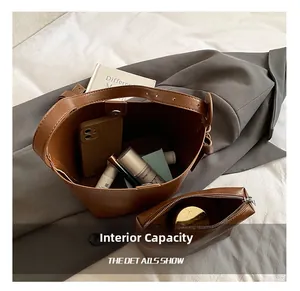 Detailed interior of vintage brown leather bucket bag showing large capacity and inner pouch