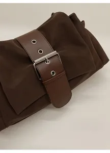Gros plan du sac oreiller rétro marron foncé avec boucle métallique et détails de ceinture