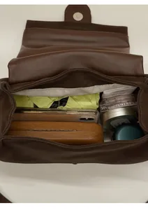 Vue de dessus du sac en cuir marron montrant l'intérieur spacieux pour téléphone et objets