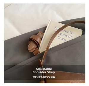 Detail of adjustable leather strap and fine texture on a brown vintage bucket bag