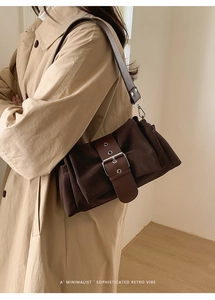 Détail du sac plissé rétro en café foncé avec texture suédine et boucle métallique