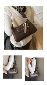 Close-up of brown crossbody bag featuring a thick braided strap and colorful wooden beads