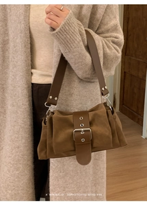 Détail du sac bandoulière rétro marron avec boucle argentée et large sangle en cuir