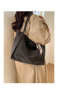 Detail of dark brown matte leather tote bag featuring a vintage pattern decorative scarf