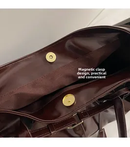 Detail view of the magnetic buckle closure on a retro brown leather tote bag