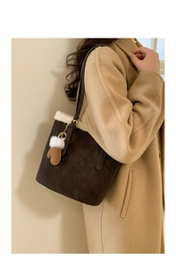 Detail of suede tote bag with faux fur trim and creative glove pendant accessory