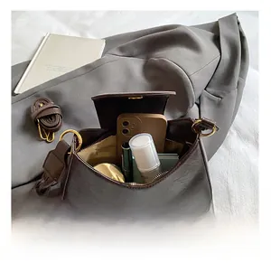 Detail showing the internal storage of the dark brown leather shoulder bag and essentials