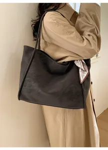 Macro shot of large matte tote bag with paisley silk scarf detail on a model's shoulder
