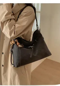 Détail d'un grand sac Hobo vintage marron avec charm léopard pour le trajet quotidien