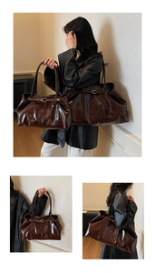 Detail view of large and small dark brown patent leather tote bags with metal buckles
