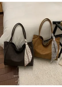 Detail of vintage tote bags in brown leather with floral scarves in a cozy autumn setting