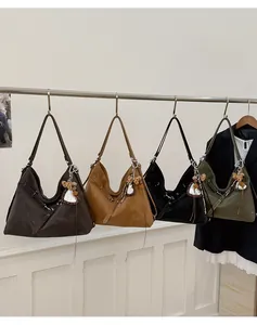 Sélection de cabas rétro en cuir huilé de différentes couleurs suspendus sur une tige