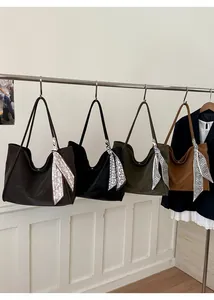 Detail view of large tote bags in four colors with paisley scarf accessories on handles