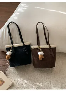 Detail of lamb wool trim on black and brown bucket bags with mini glove pendants