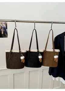 Detail of plush faux fur trim on suede tote bags featuring a cute glove-shaped charm