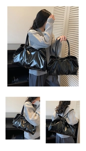 Detail view of glossy black leather tote bag featuring pleated design and slim shoulder straps