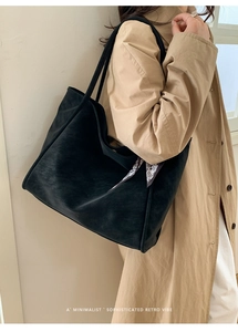 Minimalist black tote bag with retro patterned scarf detail on a beige trench coat