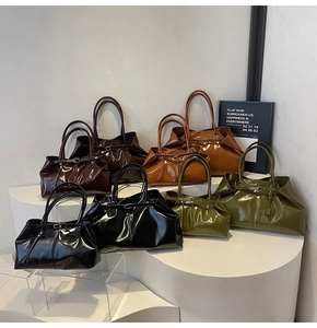 Artistic display of glossy leather tote bags in dark brown, caramel, black, and olive green
