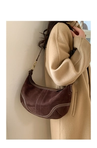 Détail du sac demi-lune en daim marron avec surpiqûres blanches et boucle dorée