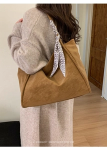 Brown suede tote bag with geometric silk scarf detail worn by model in minimalist setting