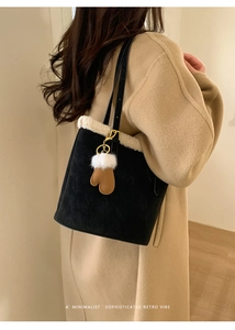 Detail of black suede tote with faux fur trim and cute brown glove charm attachment