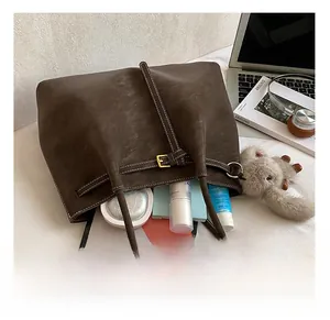 Detail showing high-capacity interior of dark brown tote bag with daily essentials and tablet