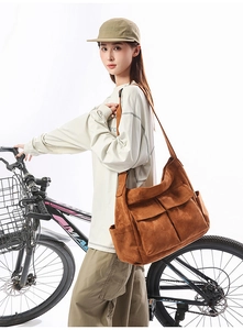 Macro detail of brown oversized canvas crossbody bag with functional front utility pockets