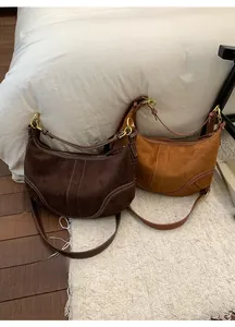 Détails des sacs à main en daim café et caramel avec boucles rétro et coutures fines