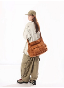 Detailed view of brown oversized canvas shoulder bag with dual front flap pockets