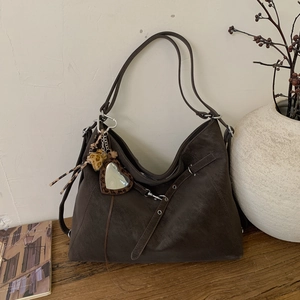 Détail du cabas vintage avec breloque cœur léopard et bandoulière en cuir réglable